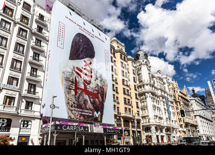 Riesige Plakatwand, die das Gerüst an einer Gebäudefront bedeckt, Gran Via, Madrid, Spanien. Stockfoto