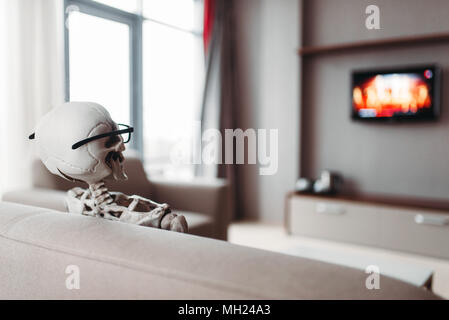 Skelett in Gläsern sitzen auf der Couch und Fernsehen. Stockfoto