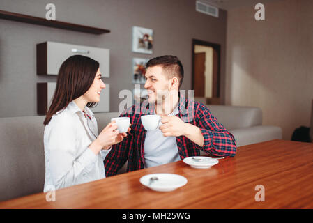 Glücklich Liebe paar Getränke Kaffee an den hölzernen Tisch Stockfoto