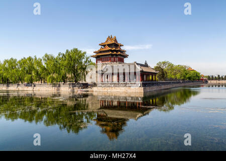 Nordostecke Turm der Verbotenen Stadt in Peking, China. Eine Reflexion der Turm und Willow Bäume können im Graben rund um die Stadt gesehen werden. Stockfoto