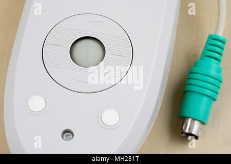Alte Computer Maus, die auf dem Prinzip einer Kugel auf einem Holztisch. Computer Zubehör mit Computern verwendet. Hellen Hintergrund. Stockfoto
