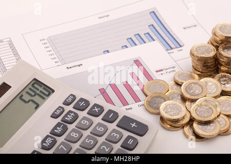 Ein Rechner sitzen auf einige Grafiken beschriftet Einsparungen und Mittel mit einigen neuen (Post 2016) Pound Münzen. Stockfoto