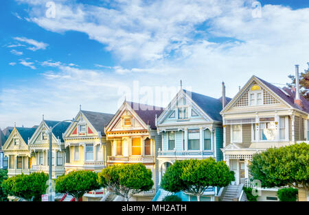 Am späten Nachmittag Sonne leuchtet eine Reihe von bunten Viktorianischen Häusern als Painted Ladies gegenüber von Alamo Square bekannt. Zwischen 1892 und 1896 gebaut, diese Ho Stockfoto