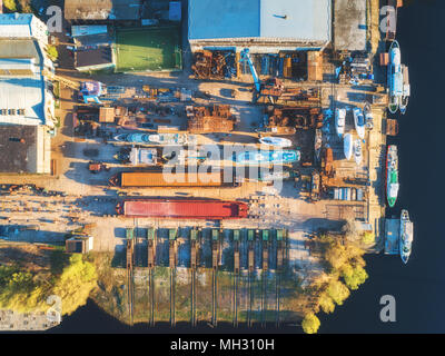 Luftaufnahme der Schiffe und Boote im Trockendock für Reparaturen. Blick von oben auf die Eisen rostet Schiff im Trockendock für die Sanierung. Industrial Szene mit Old Yacht Stockfoto