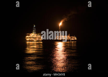 FPSO-tanker Schiff in der Nähe der Bohrinsel in der Nacht. Offshore Öl- und Gasindustrie Stockfoto