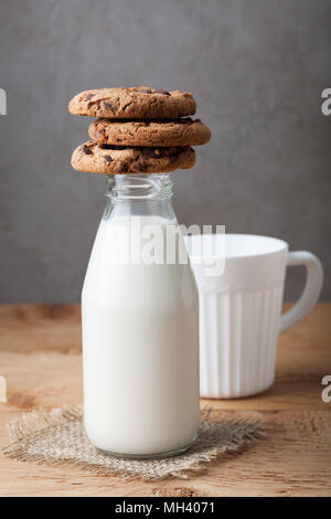 Mit Milch und Chocolate Chip Cookies auf dunklem Hintergrund Flasche. Stockfoto