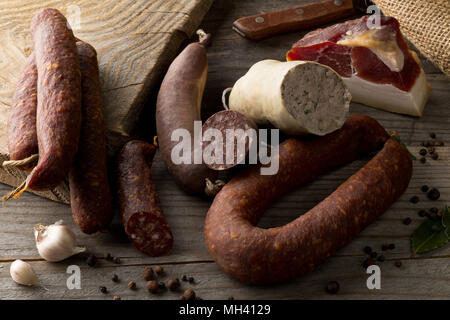 Auswahl deutscher Wurstspezialitäten hart kuriert Salami, Leberwurst (Leberwurst), Blutwurst (Blutwurst) und Speck auf dem Küchentisch Stockfoto