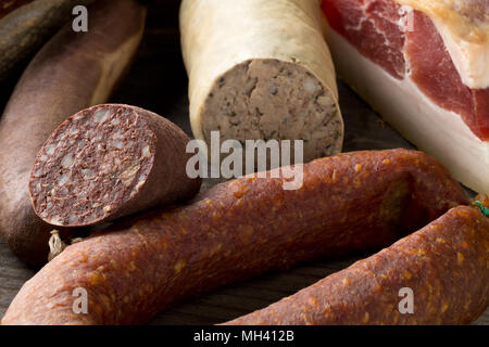 Auswahl deutscher Wurstspezialitäten hart kuriert Salami, Leberwurst (Leberwurst), Blutwurst (Blutwurst) und Speck auf dem Küchentisch Stockfoto