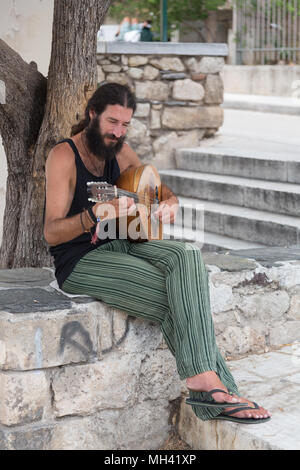 Single bärtige griechische Mann spielt Mandoline im Schatten in Athen, Griechenland Stockfoto