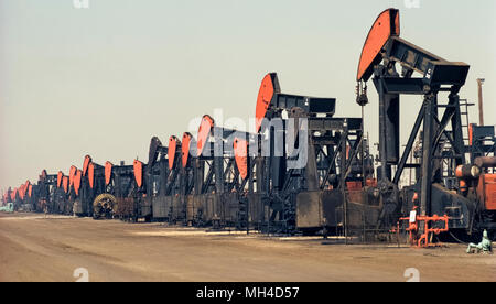 Eine lange Reihe von mechanischen Pumpen emsig Gewinnung von Erdöl aus dem Untergrund ist auf ein DUNSTIGER Tag in Huntington Beach, Kalifornien, USA, wo "schwarze Gold", die erstmals in 1920 angeschlagen wurde und begann ein Ölboom in Südkalifornien gesehen. Offiziell genannten pumpjacks sondern auch als nickenden Esel bekannt, diese vintage Ölplattformen wurden im Jahr 1972 fotografiert. In den letzten Jahren haben viele der Pumpen und Öl- bohrtürmen in dieser Küstenstadt von Wohnsiedlungen ersetzt wurden. Historisches Foto. Stockfoto