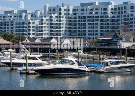 Yachten festgemacht an der Marina Bay Docks, vor einer Waterfront Promenade, Restaurants und Kondominium Komplex, in Quincy, Massachusetts, USA. Stockfoto