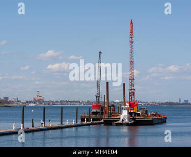 Marine bau Lastkähne mit Kränen für Rammen. Marina Bay, Quincy, MA. Stockfoto