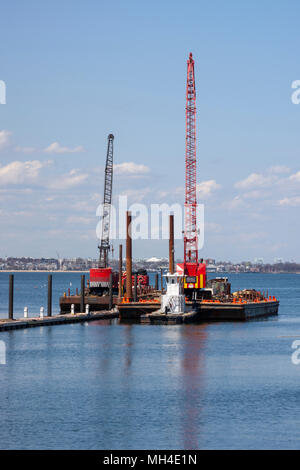 Marine bau Lastkähne mit Kränen für Rammen. Marina Bay, Quincy, MA. Stockfoto