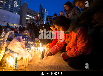 Toronto, Kanada. 29 Apr, 2018. Ein Mädchen (R) leuchten Kerzen ihren Respekt während der Vigil am TorontoStrong Mel Lastman Square in Toronto, Kanada, April 29, 2018 zu zahlen. Tausende von Kanadiern nahmen an der TorontoStrong Mahnwache am Sonntag die Opfer der letzten Montag tödlichen Van angriff, links 10 Tote und 15 Verletzte zu erinnern. Credit: Zou Zheng/Xinhua/Alamy leben Nachrichten Stockfoto