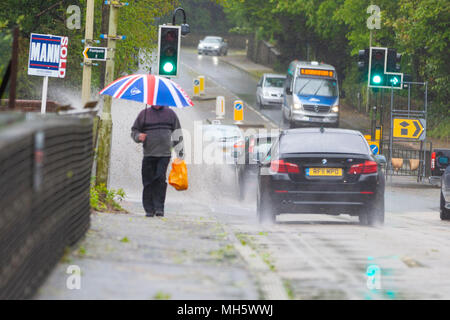 Ashford, Kent, Großbritannien. 30 Apr, 2018. UK Wetter: Starker Regen und starken Winden in Ashford. Dieser Mann, der einen Union Jack Dach erhält Glück gehabt, denn er ist völlig ahnungslos er nur knapp verhindert ein Einweichen von einer Beschleunigung. Credit: Paul Lawrenson/Alamy leben Nachrichten Stockfoto