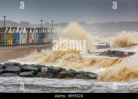 Southwold, Suffolk, Großbritannien. 30.April 2018. Raue See Absturz über die Promenade und der Strand Hütten, Southwold, Suffolk, Großbritannien. Stockfoto