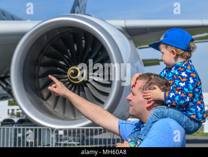 28 April 2018, Deutschland, Schönefeld: Die Besucher Vater Lars und sein Sohn Leon bewundern, ein Flugzeug des Typs Airbus A350 auf der ILA Berlin Air Show. Über 200 Flugzeuge werden während der ILA 2018 präsentiert. Die Veranstalter erwarten rund 150.000 Besucher. Foto: Patrick Pleul/dpa-Zentralbild/dpa Stockfoto