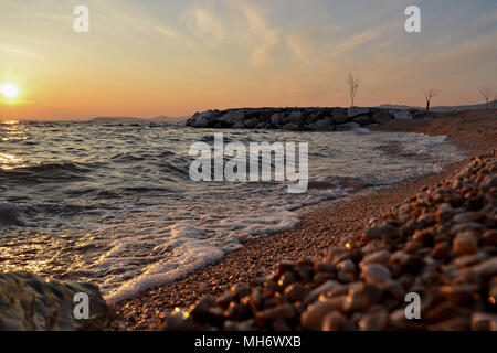 Kleine Wellen an der Küste während der Goldenen Stunde entlang der Küste kommen. Eine kühne und dramatische Szene von Blau, frisches Wasser. Horizontale, kopieren. Stockfoto