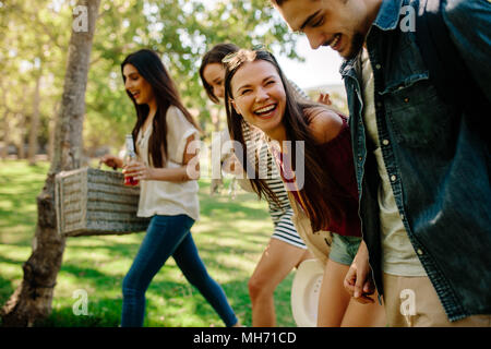 Gruppe von Jugendlichen auf Picknick im Park. Lächelnd Mann und Frau Freunde zu Fuß durch den Park. Stockfoto