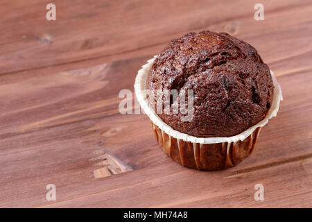 Nahaufnahme eines köstlichen Schokolade muffin auf braunem Holz- Hintergrund mit einem Platz für Text Stockfoto