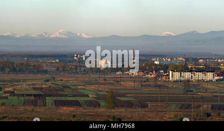 Schöne ruhige Feder Panorama der gepflügt und grüne Felder und Wiesen auf den Hintergrund der Bäume, Wald und entfernten Blick auf die herrliche Bergwelt w Stockfoto