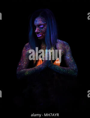 Portrait von schöne Mode Frau Yoga in Neon UF Licht. Modell Mädchen mit fluoreszierenden Creative Psychedelic Make-up, Art Design der weiblichen Disco Dancer Modell im UV Stockfoto