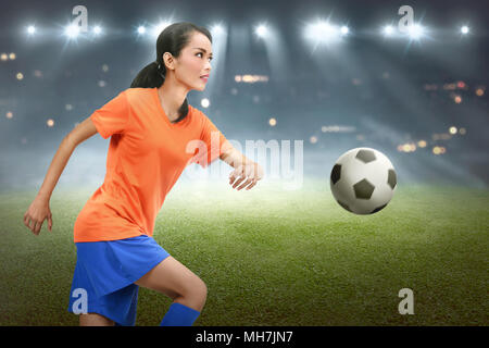 Asiatische Fußball-Spieler Frau, die ihre Fähigkeiten auf dem Feld konzentriert Stockfoto