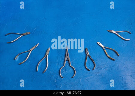 Medizinischen Metall kieferorthopädische Tools auf blauem Hintergrund Stockfoto