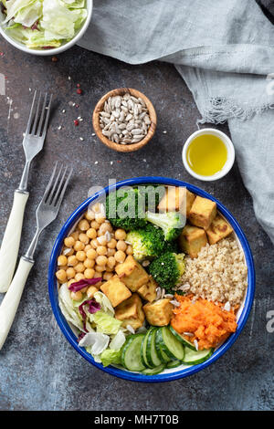 Bunte buddha Schüssel mit Quinoa, Süßkartoffel, Tofu, Kichererbsen, Gurken, Brokkoli und Salat. Gesunde trendy Mahlzeit. Nahrhaften veganen Mittagessen Schüssel Stockfoto