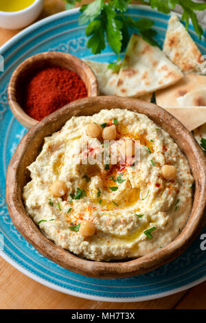 Kichererbse Hummus mit Paprika und pita Chips. Hausgemachte Hummus. Gesund vegan Kichererbse Verbreitung in der Schüssel. Detailansicht, selektiver Fokus Stockfoto