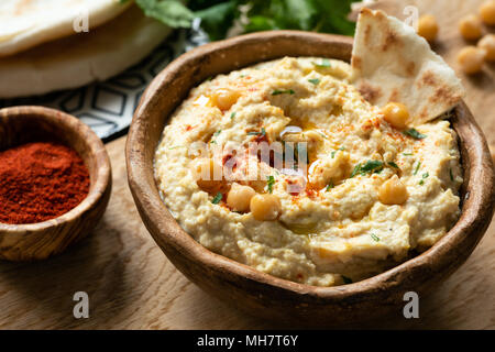 Hausgemachte Kichererbse hummus in Schüssel mit Fladenbrot serviert und geräucherter Paprika. Detailansicht, selektiver Fokus Stockfoto