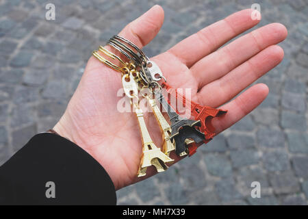 Hand, die kleine Eiffel Towers vor der Bürgersteig Stockfoto