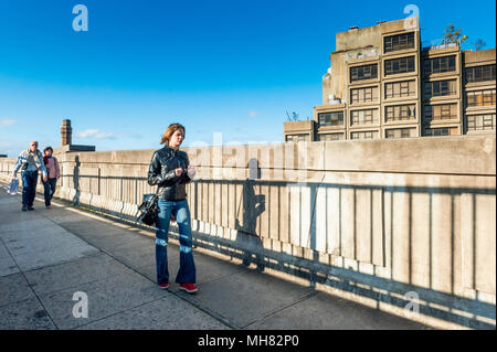 Eine junge Dame verloren in Gedanken macht sich auf den Weg über die Sydney Harbour Bridge zu Fuß an einem sonnigen Tag in Sydney, New South Wales. Stockfoto