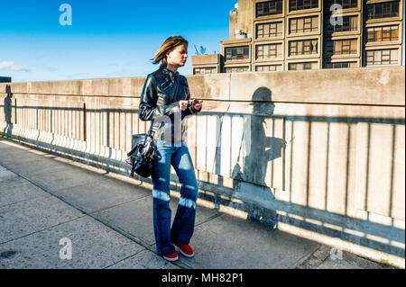 Eine junge Dame verloren in Gedanken macht sich auf den Weg über die Sydney Harbour Bridge zu Fuß an einem sonnigen Tag in Sydney, New South Wales. Stockfoto