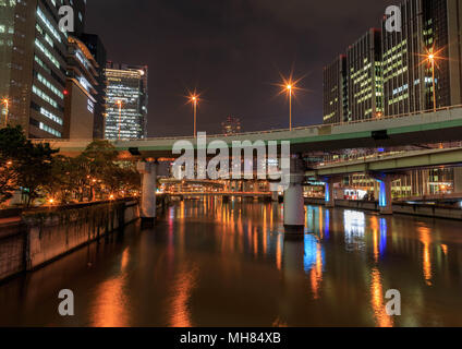 Osaka, Japan - 24. September 2013: Brücken und Autobahnen Kreuz eine Wasserstraße bei Nacht Stockfoto