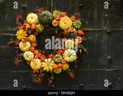 Handgefertigte Kranz der kleine Kürbisse und Zucchini auf eine alte Tür Stockfoto