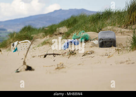 Kunststoffbehälter und Fischernetze an Harlech Strand in West Wales Großbritannien ein Beispiel für die viele Stücke aus Kunststoff, die Verschmutzung des Meeres Stockfoto