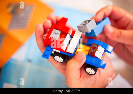 Tambow, Russische Föderation - Dezember 19, 2013 Kind Gebäude Lego Auto. Es gibt Lego Anleitungen im Hintergrund. Stockfoto