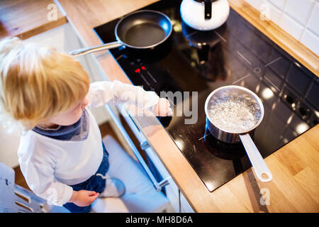 Kleinkind Junge in gefährliche Situation zu Hause. Kind Sicherheitskonzept. Stockfoto