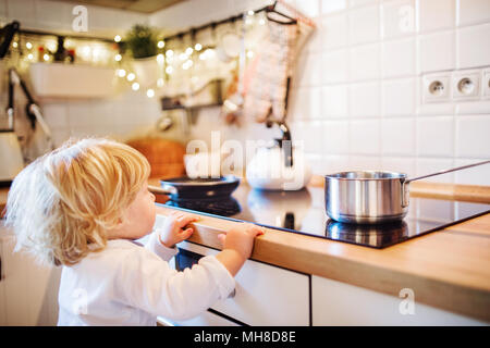 Kleinkind Junge in gefährliche Situation zu Hause. Kind Sicherheitskonzept. Stockfoto