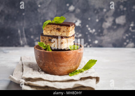 Raw vegan Kuchen mit Schokolade, einen Stapel von Scheiben geschnittenen Stücke in eine hölzerne Schüssel. Gesunde vegane Ernährung Konzept. Stockfoto