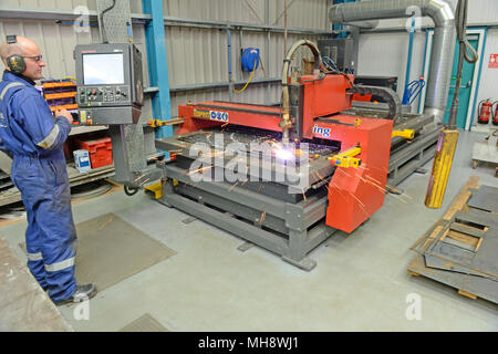 Mann bei der Arbeit auf einer metallenen Plasmaschneidemaschine in einer Werkstatt Stockfoto