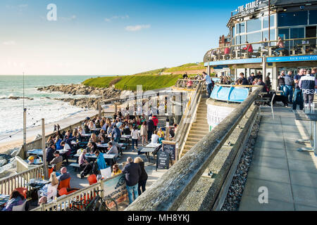 Urlauber auf den Fistral Beach Bar genießen die Abendsonne in Newquay in Cornwall. Stockfoto