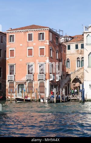 Die Einheimischen genießen spritz Dämmerschoppen an der beliebten Taverna al Remer, Campiello del Remer, Grand Canal, Santa Croce, Venedig, Venetien, Italien. Gotische stairca Stockfoto