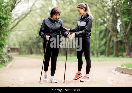 Frauen gehen mit wanderstöcke im Park Stockfoto