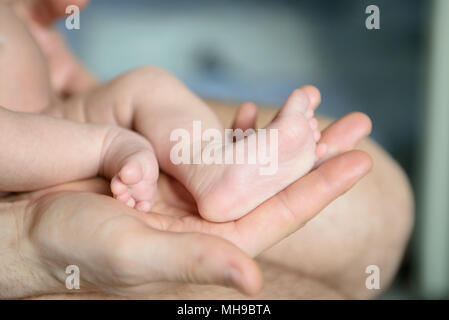 Kinder die Füße in den Händen des Vaters Nahaufnahme Stockfoto