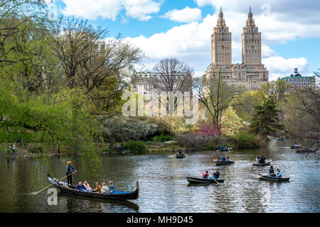 New York, USA, 29. April 2018. Touristen genießen Sie Bootsfahrten und sogar eine Gondel im New Yorker Central Park. Die legendären San Remo Gebäude ist in der Ba gesehen Stockfoto