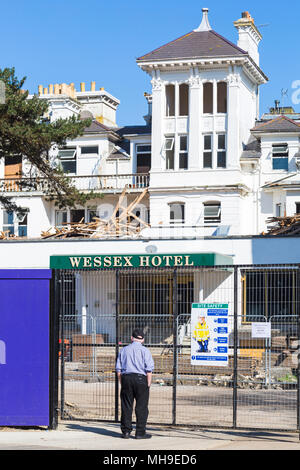 Mann, der im April den Abriss des Wessex Hotels in Bournemouth, Dorset, Großbritannien, betrachtet Stockfoto