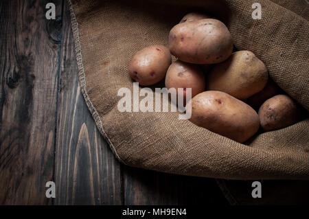 Ernte Kartoffeln in sackleinen Sack auf Holz Hintergrund Stockfoto