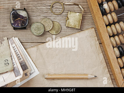 Alte Banknoten und Münzen und Abakus auf einem Holztisch Stockfoto